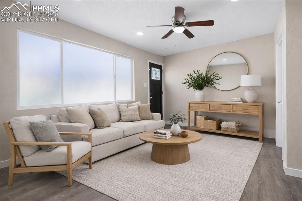 1901 Whitman Road Colorado Springs, CO 80910 - Photo 34 of 35 a living room with furniture a fireplace and a chandelier