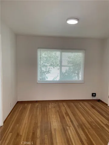 a view of a room with wooden floor and window