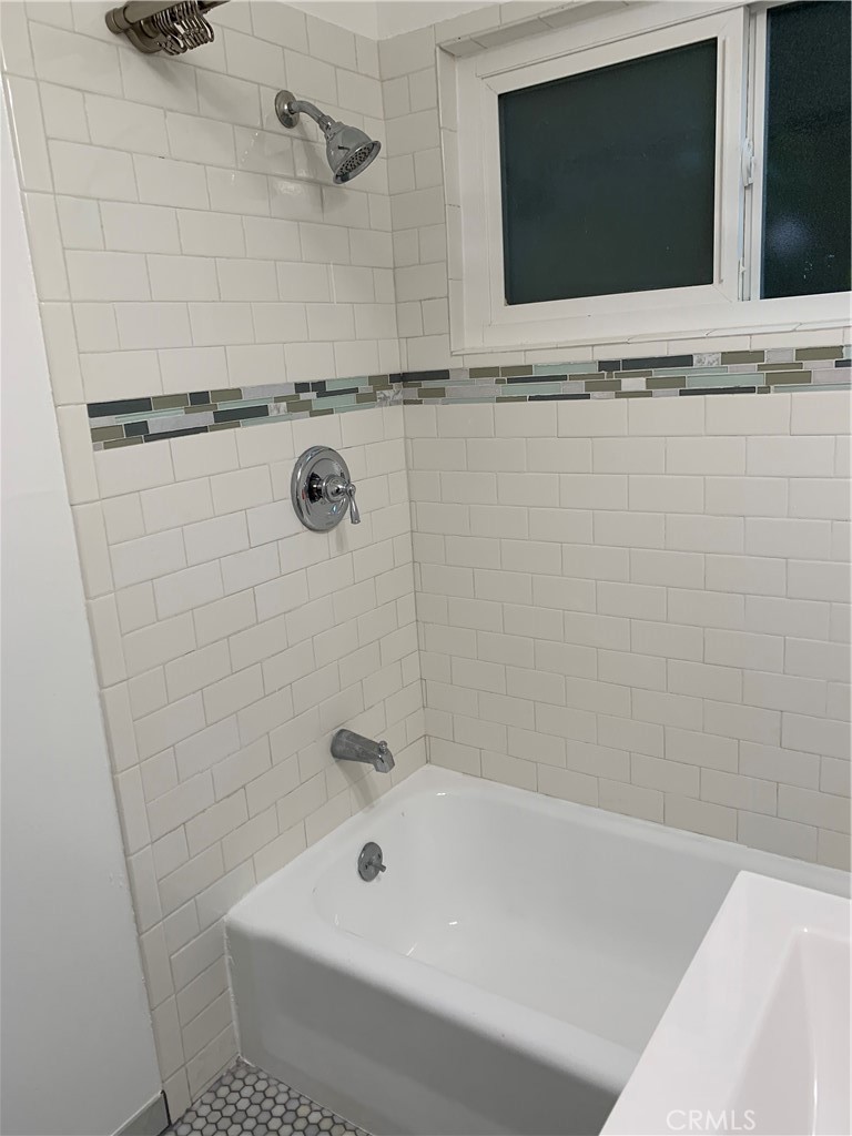 4806 Clarke Street, Unit 2 Oakland, CA 94609 - Photo 4 of 13 a bathroom with a tub and a flat screen tv