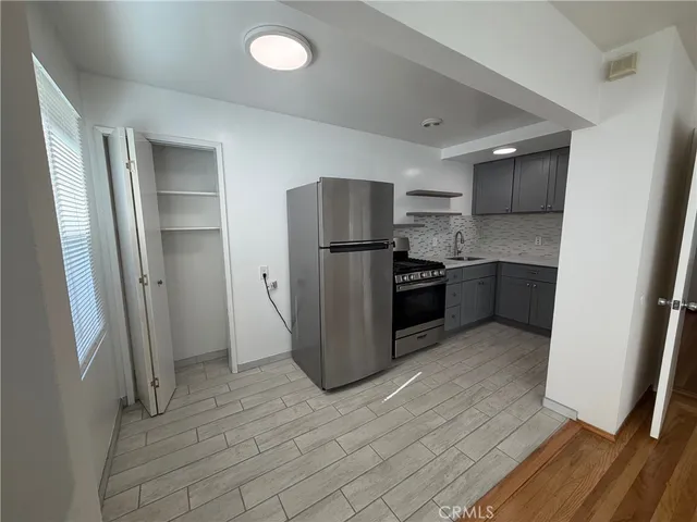 a kitchen with stainless steel appliances granite countertop a refrigerator and a sink