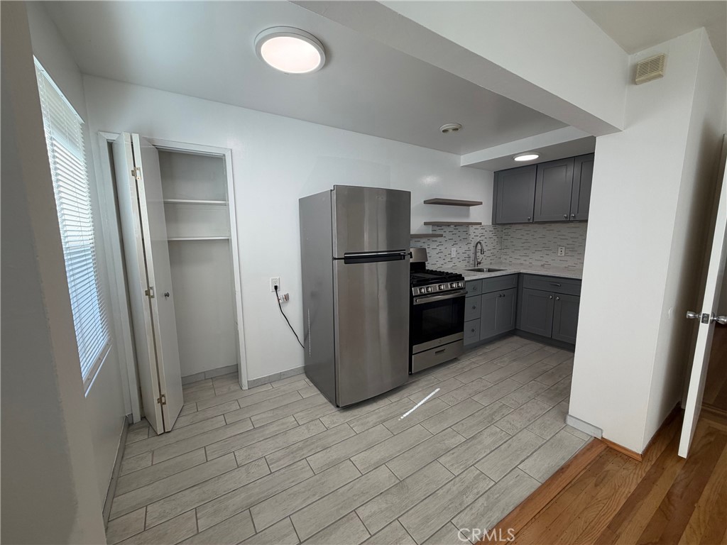 4806 Clarke Street, Unit 2 Oakland, CA 94609 - Photo 7 of 13 a kitchen with stainless steel appliances granite countertop a refrigerator and a sink