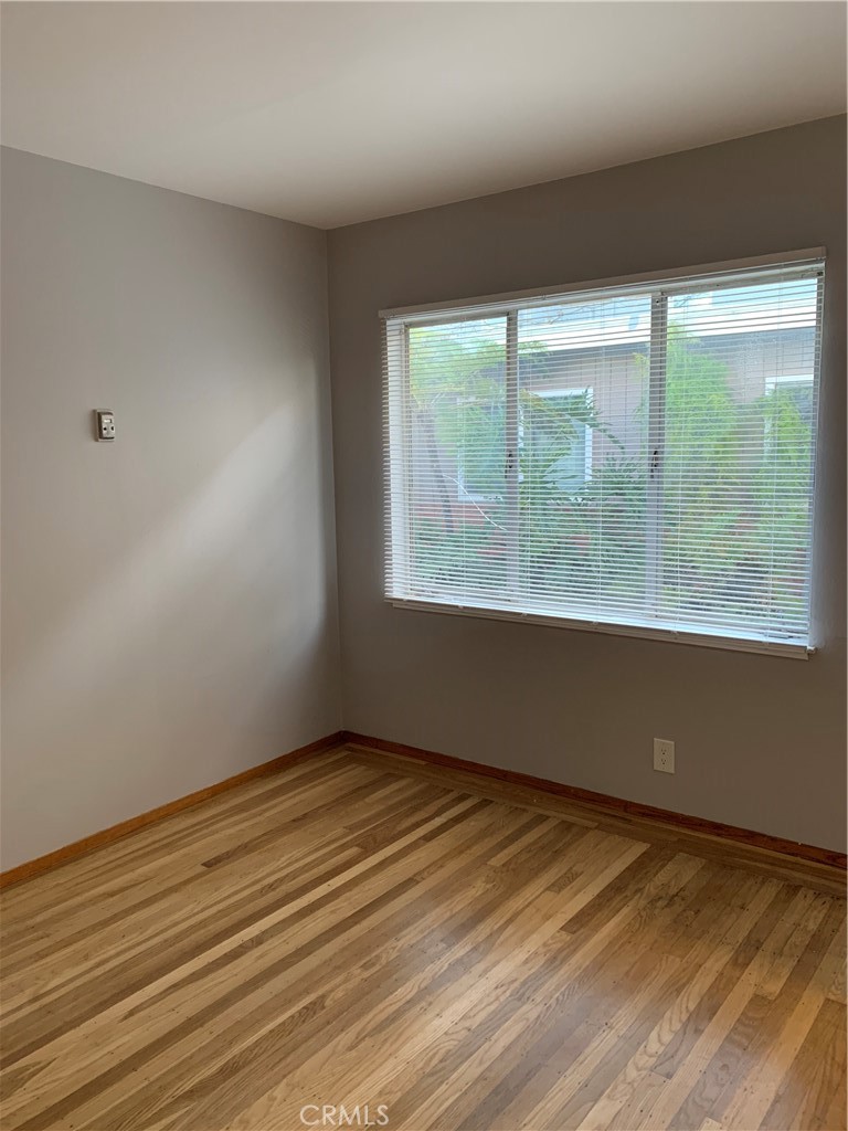 4806 Clarke Street, Unit 2 Oakland, CA 94609 - Photo 10 of 13 a view of an empty room with wooden floor and a window
