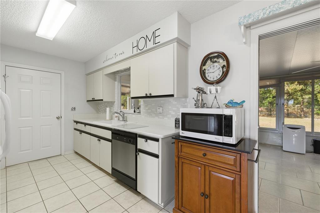10689 Southeast 174th Loop Summerfield, FL 34491 - Photo 20 of 45 a kitchen with stainless steel appliances granite countertop a stove a sink and a clock on the wall