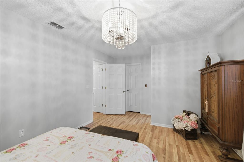 10689 Southeast 174th Loop Summerfield, FL 34491 - Photo 28 of 45 a bedroom with a bed and a chandelier