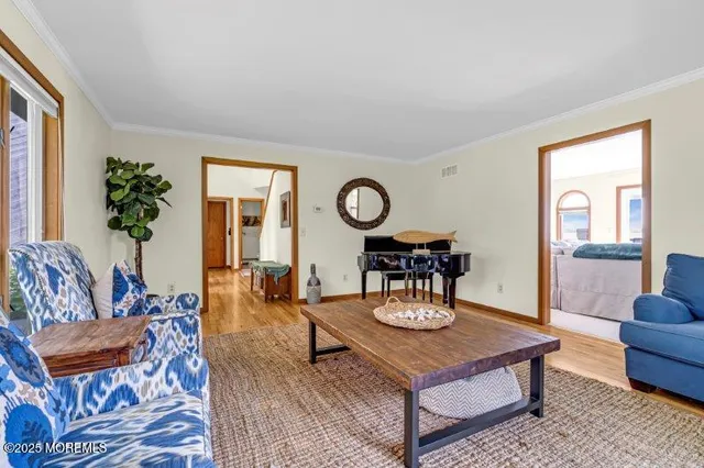 a living room with furniture and two large windows