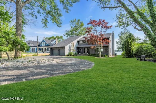 a view of a hallway to a livingroom with wooden floor and staircase