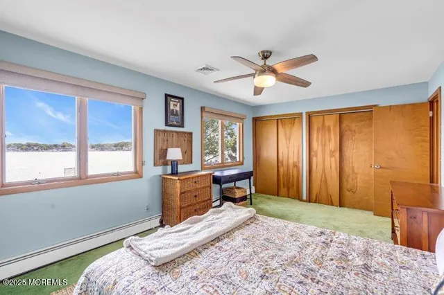 a bedroom with a large bed a flat screen tv and a dresser