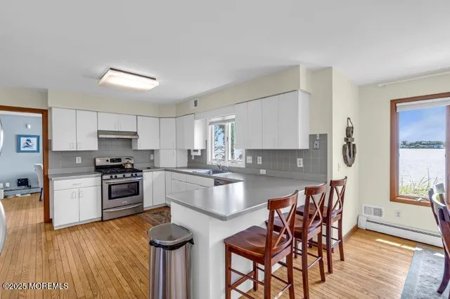 a kitchen with sink stove and wooden floor