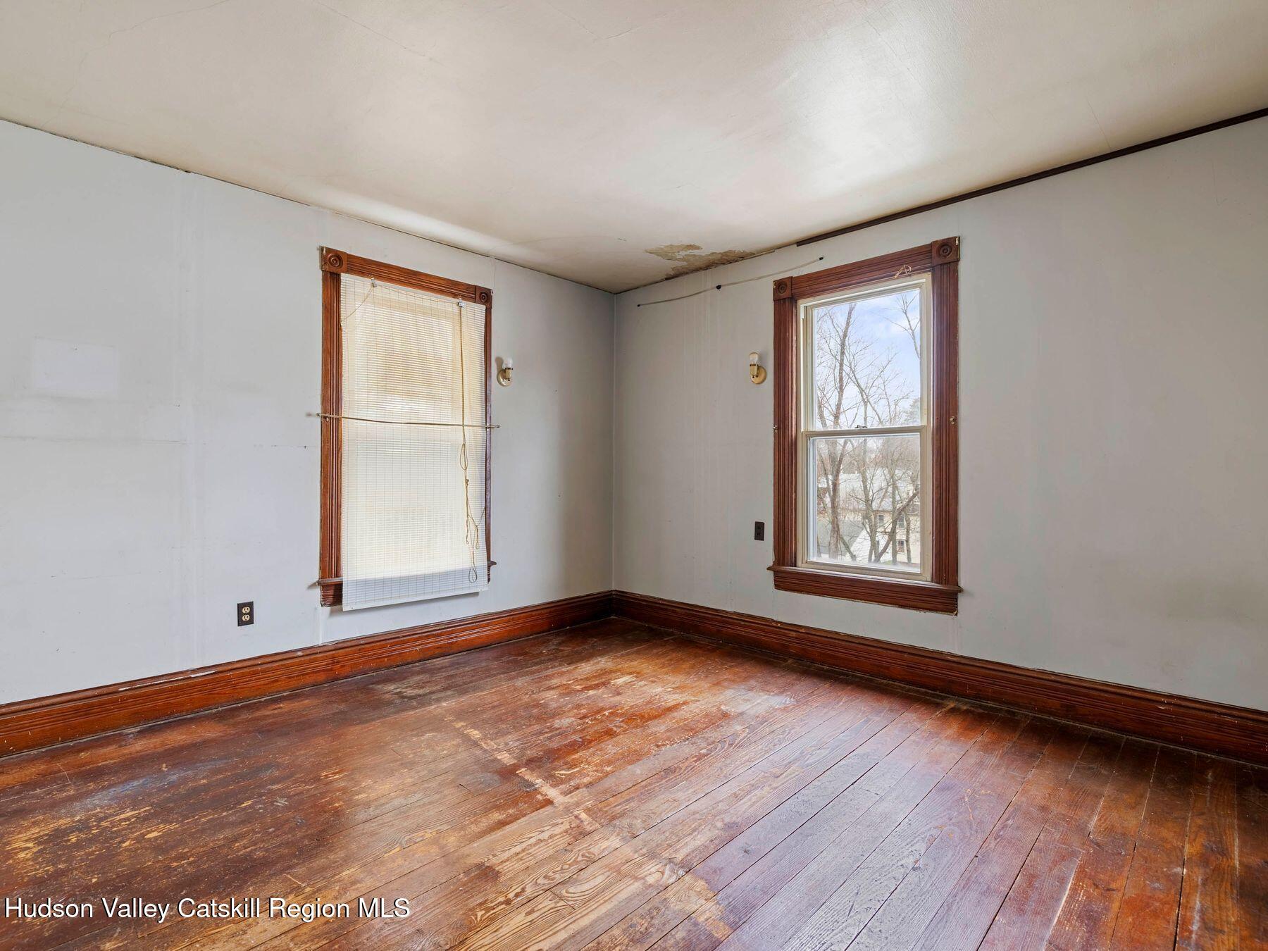 29 New Street Catskill, NY 12414 - Photo 25 of 46 an empty room with wooden floor and windows