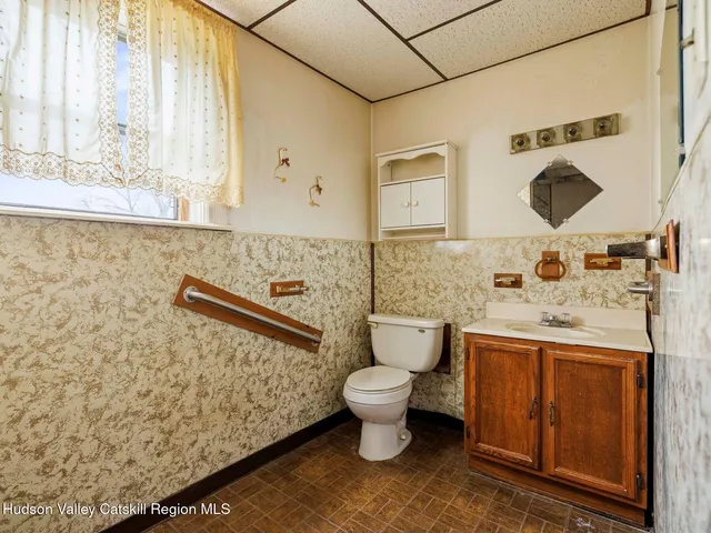 a bathroom with a toilet sink and mirror