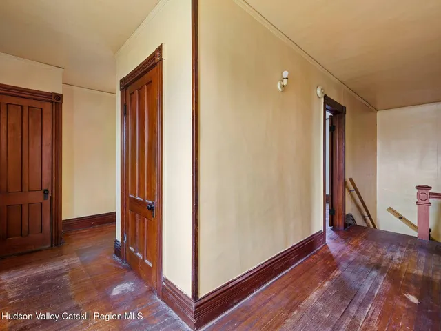 a view of a hallway with closet and wooden floor