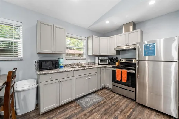 a kitchen with stainless steel appliances granite countertop a refrigerator sink and stove