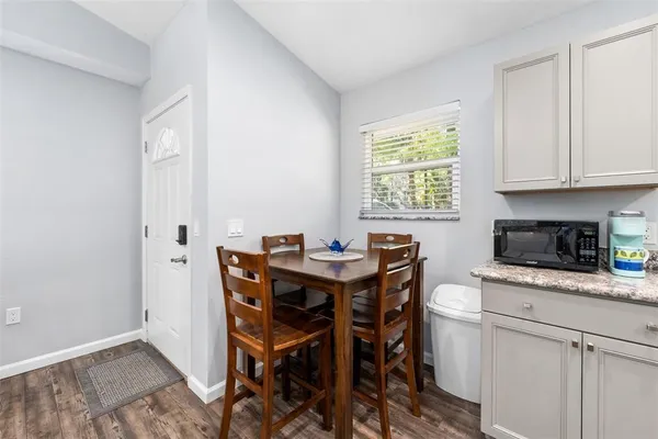 a kitchen with stainless steel appliances kitchen island granite countertop a table chairs sink and cabinets
