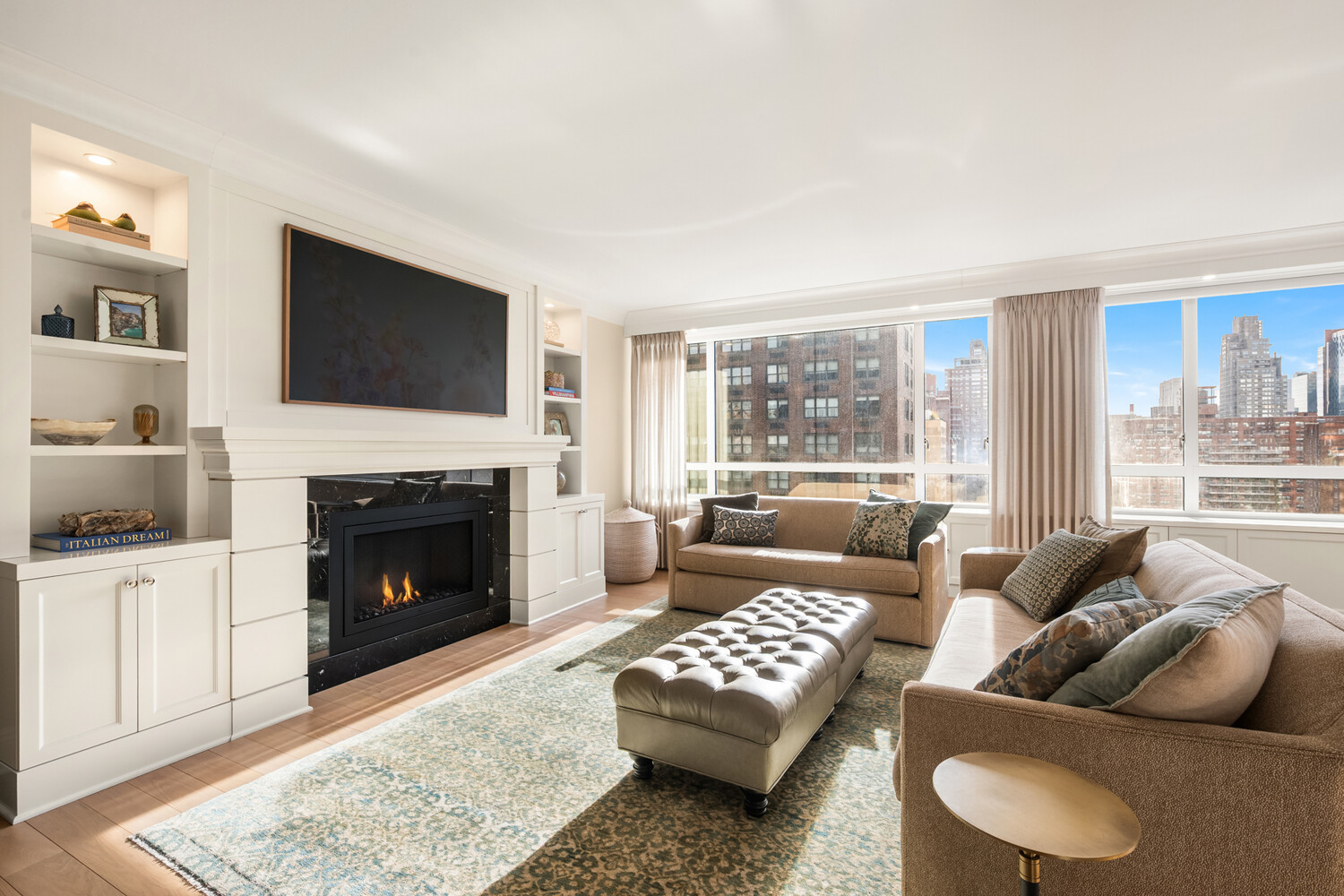 190 East 72nd Street, Unit 14D Manhattan, NY 10021 - Photo 6 of 12 a living room with furniture a flat screen tv and a fireplace