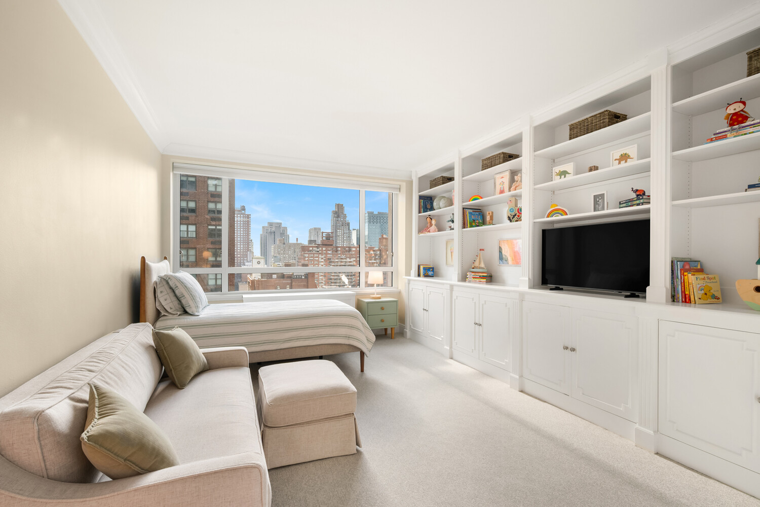 190 East 72nd Street, Unit 14D Manhattan, NY 10021 - Photo 9 of 12 a living room with furniture a flat screen tv and a floor to ceiling window