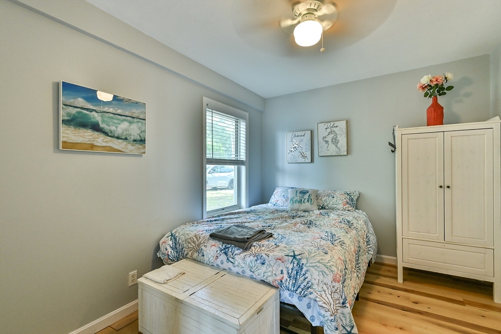 23 Lakeview Road Webster, MA 01570 - Photo 33 of 35 a bedroom with a bed and a chandelier