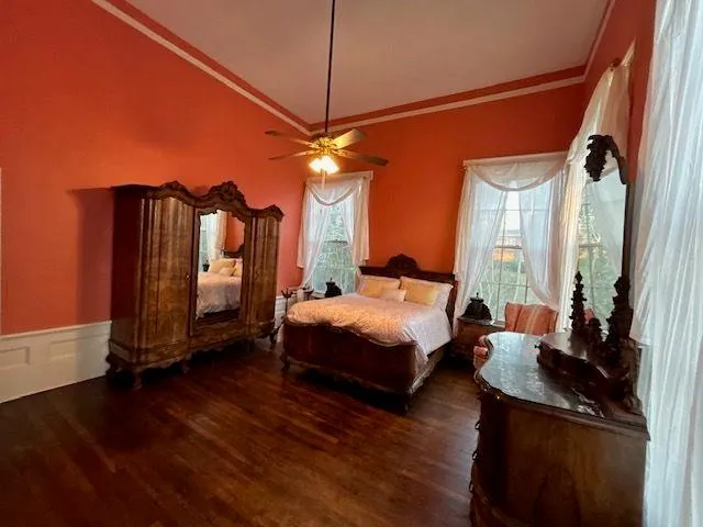 a bedroom with a bed a dresser next to a window