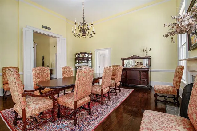 a view of a dining room with furniture a chandelier and wooden floor