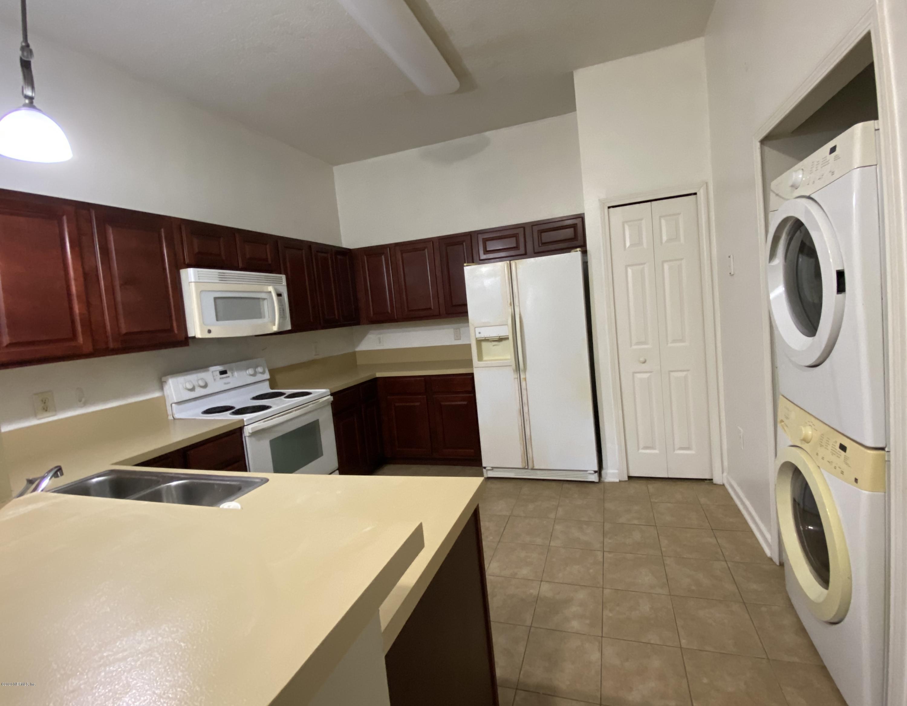 7920 Merrill Road, Unit 707 Jacksonville, FL 32277 - Photo 4 of 13 a kitchen with a refrigerator sink and washer