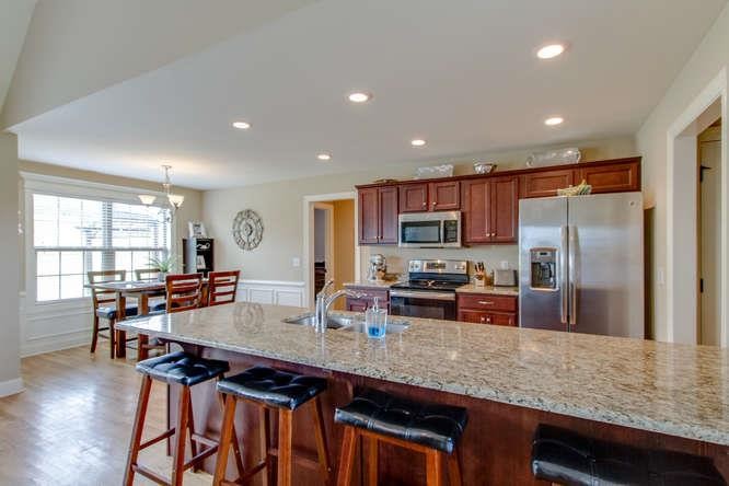 575 Neal Road Watertown, TN 37184 - Photo 8 of 28 a kitchen with stainless steel appliances granite countertop a stove top oven a sink dishwasher a dining table and chairs with wooden floor