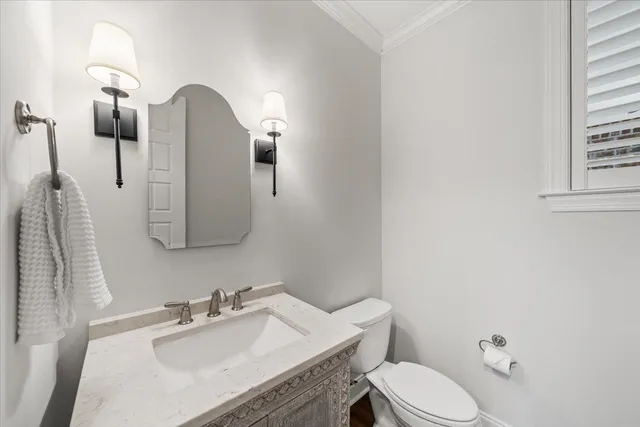 a bathroom with a sink vanity mirror and toilet