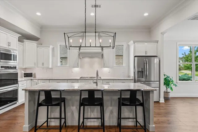 a kitchen with granite countertop a table chairs stove and cabinets
