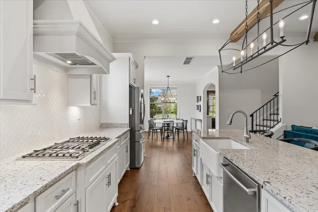 a kitchen with stainless steel appliances granite countertop a sink stove and refrigerator