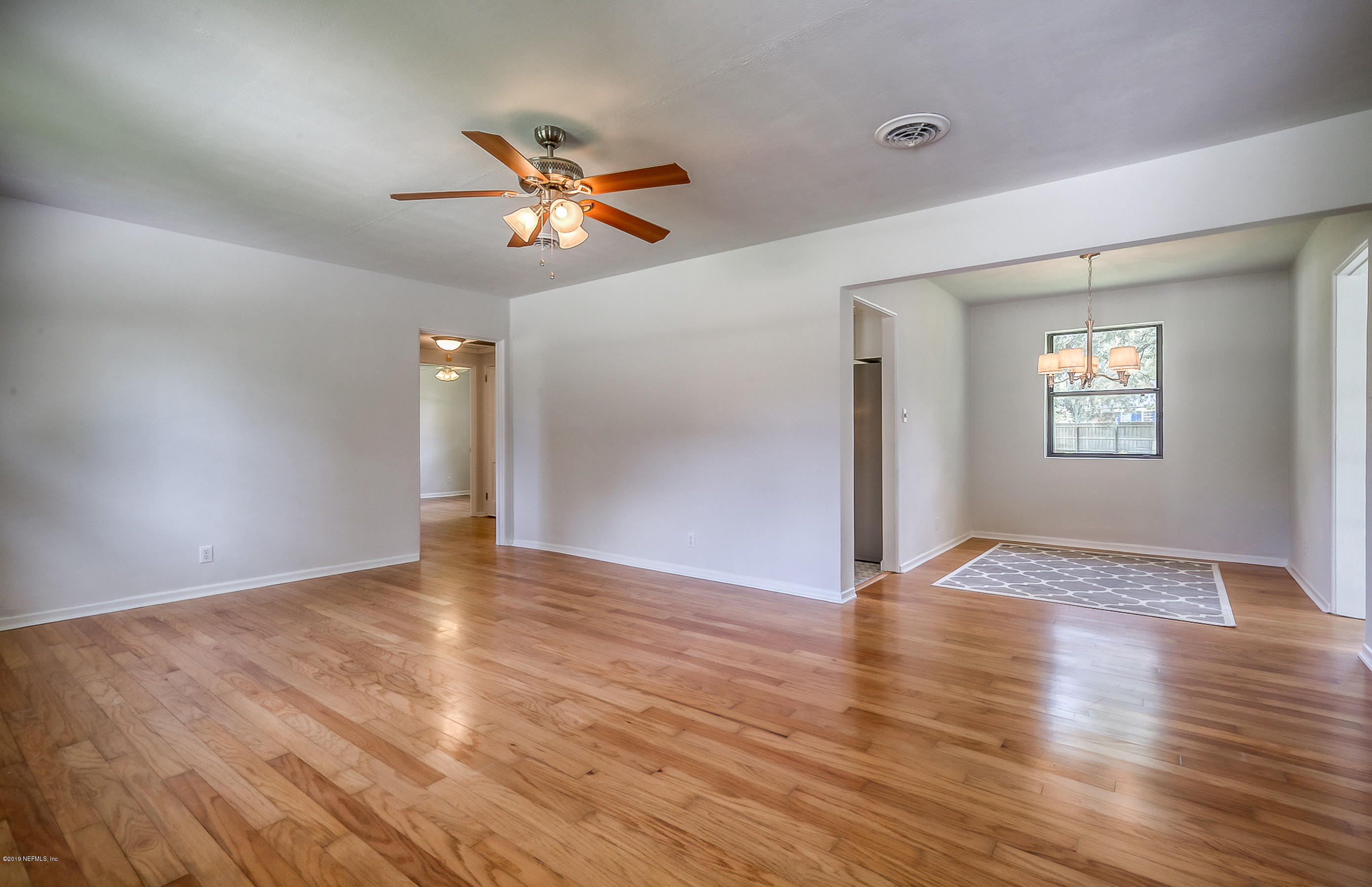4548 Milstead Road Jacksonville, FL 32210 - Photo 16 of 37 a view of an empty room with window and wooden floor