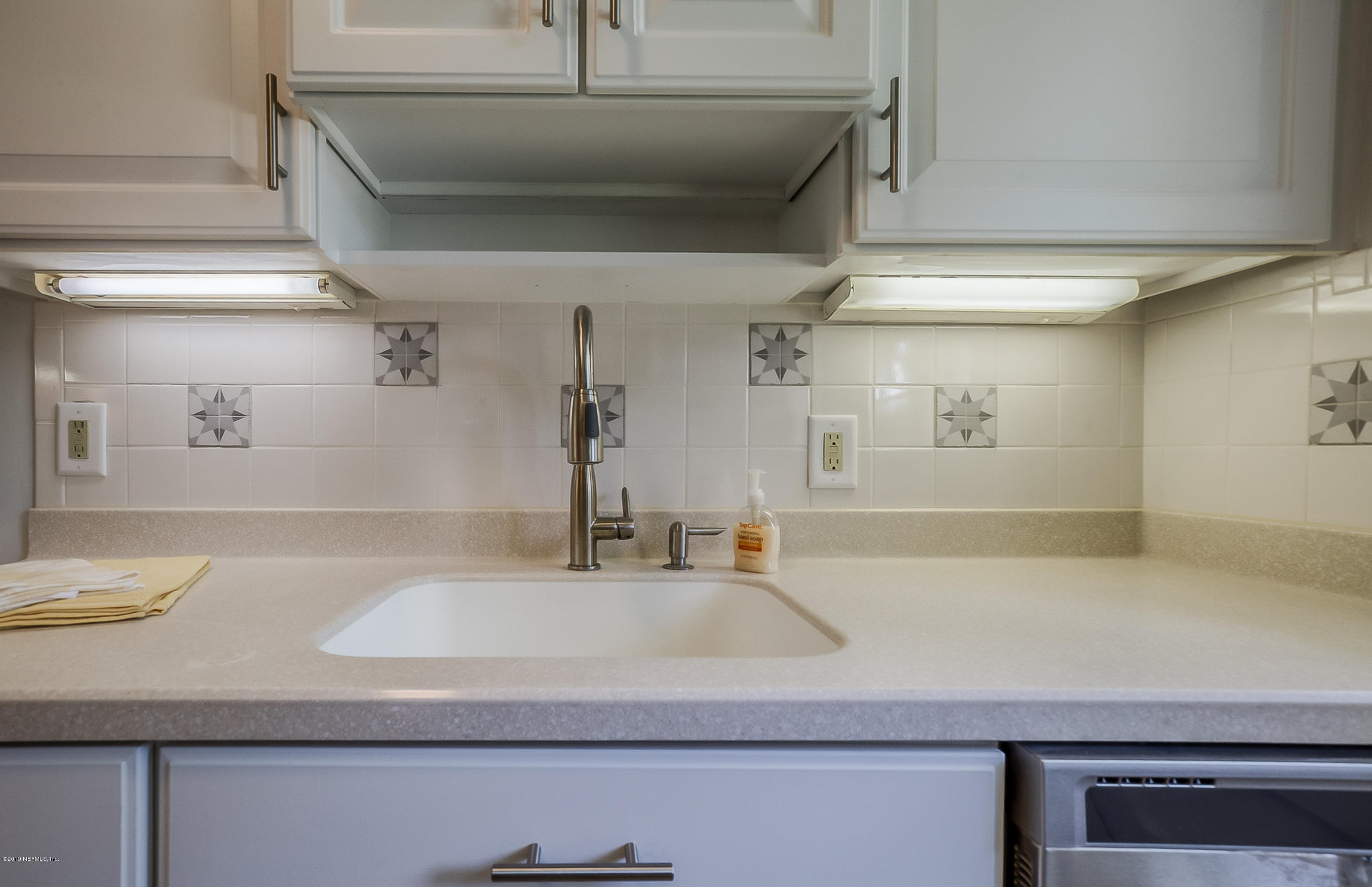 4548 Milstead Road Jacksonville, FL 32210 - Photo 33 of 37 a kitchen with a sink and a refrigerator