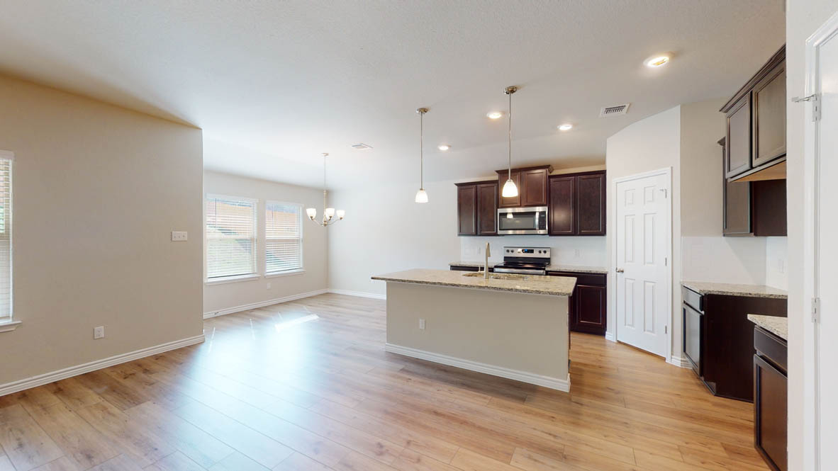 429 Creekfall Road Burnet, TX 78611 - Photo 5 of 28 A streamlined kitchen island offers dining space and an efficient work triangle, connecting to an open living area.