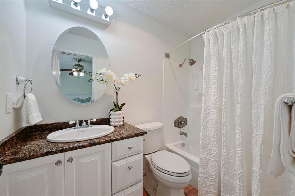 2406 Burly Oak Drive Austin, TX 78745 - Photo 9 of 21 a bathroom with a granite countertop sink a toilet and a mirror