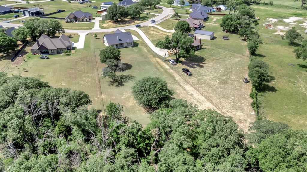 3224 North Cardinal Road Azle, TX 76020 - Photo 37 of 40 Expansive property featuring a cleared area surrounded by mature trees, a long driveway, and a residential neighborhood setting