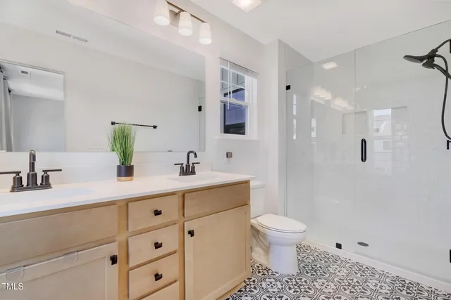 a bathroom with a sink a toilet and a mirror