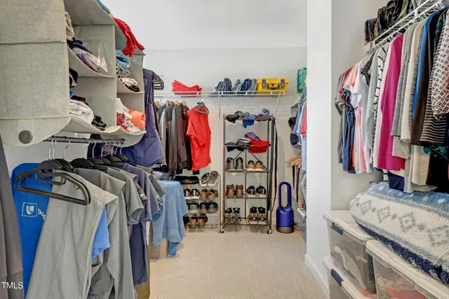 a view of walk in closet with clothes