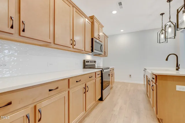 a kitchen with stainless steel appliances granite countertop a sink and dishwasher a stove with wooden floor