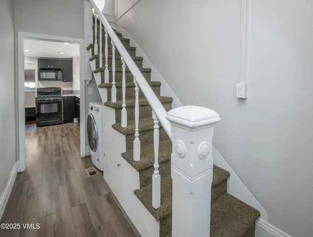 a view of entryway and hall with wooden floor