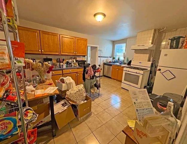 a kitchen with stainless steel appliances granite countertop a stove top oven a sink a dining table and chairs
