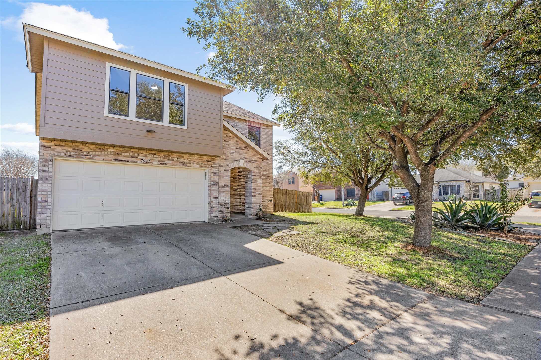7541 Redrick Drive Austin, TX 78747 - Photo 40 of 40 View of front of home featuring brick siding, an attached garage, driveway, and fence
