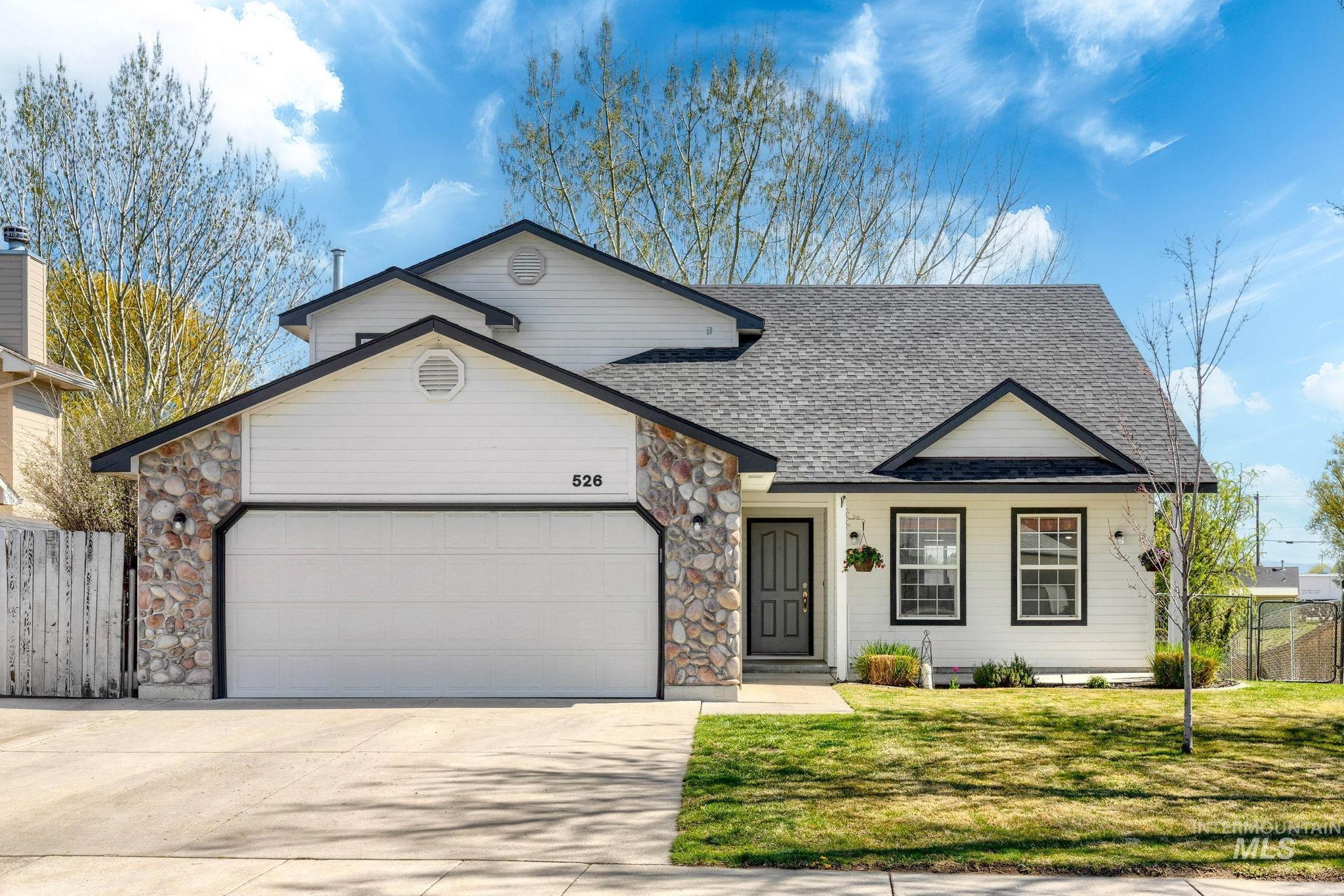 View of front of home featuring stone siding, an attached garage, and concrete driveway