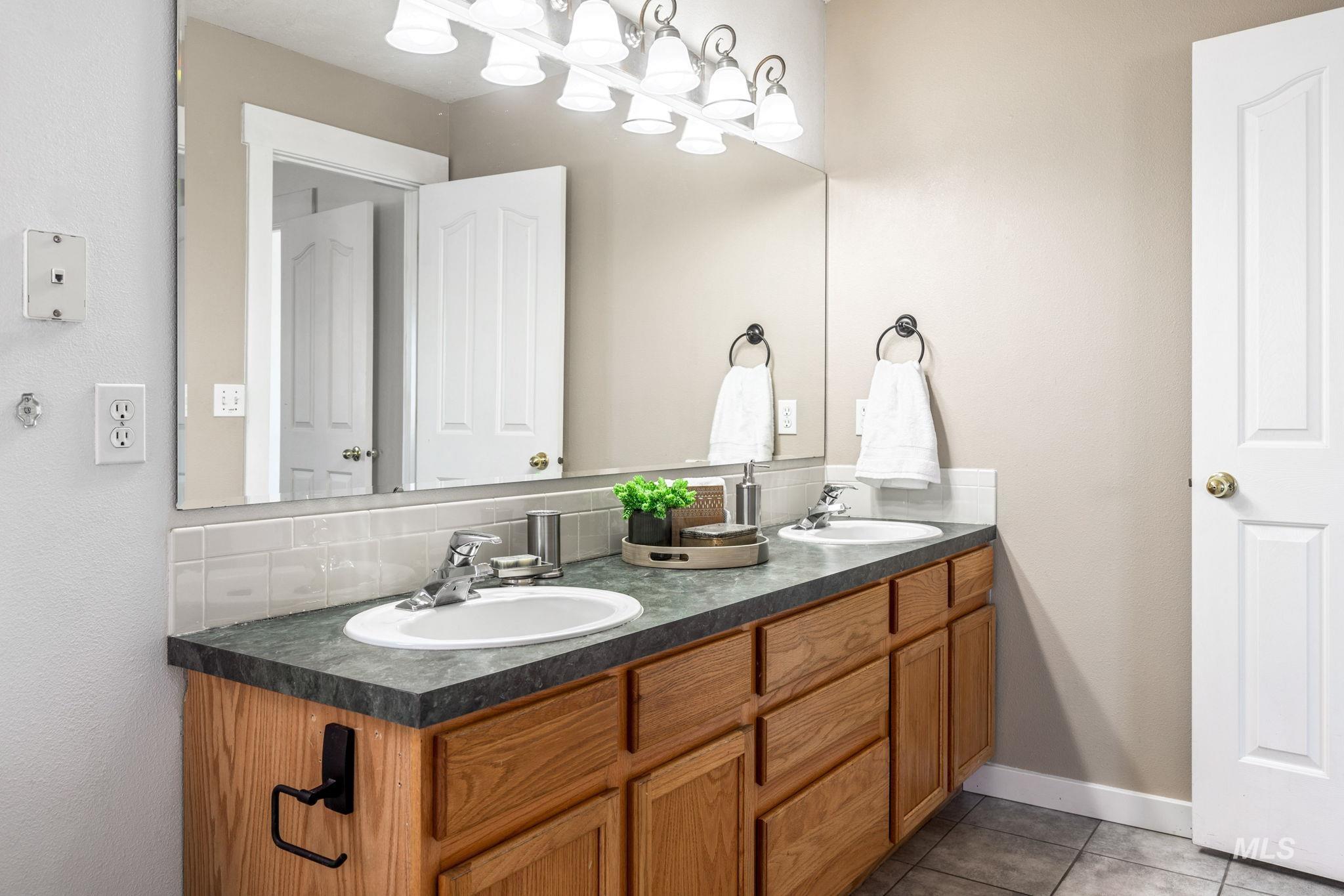 526 Cornwall Way Fruitland, ID 83619 - Photo 30 of 42 Full bathroom with double vanity, light tile patterned flooring, and backsplash