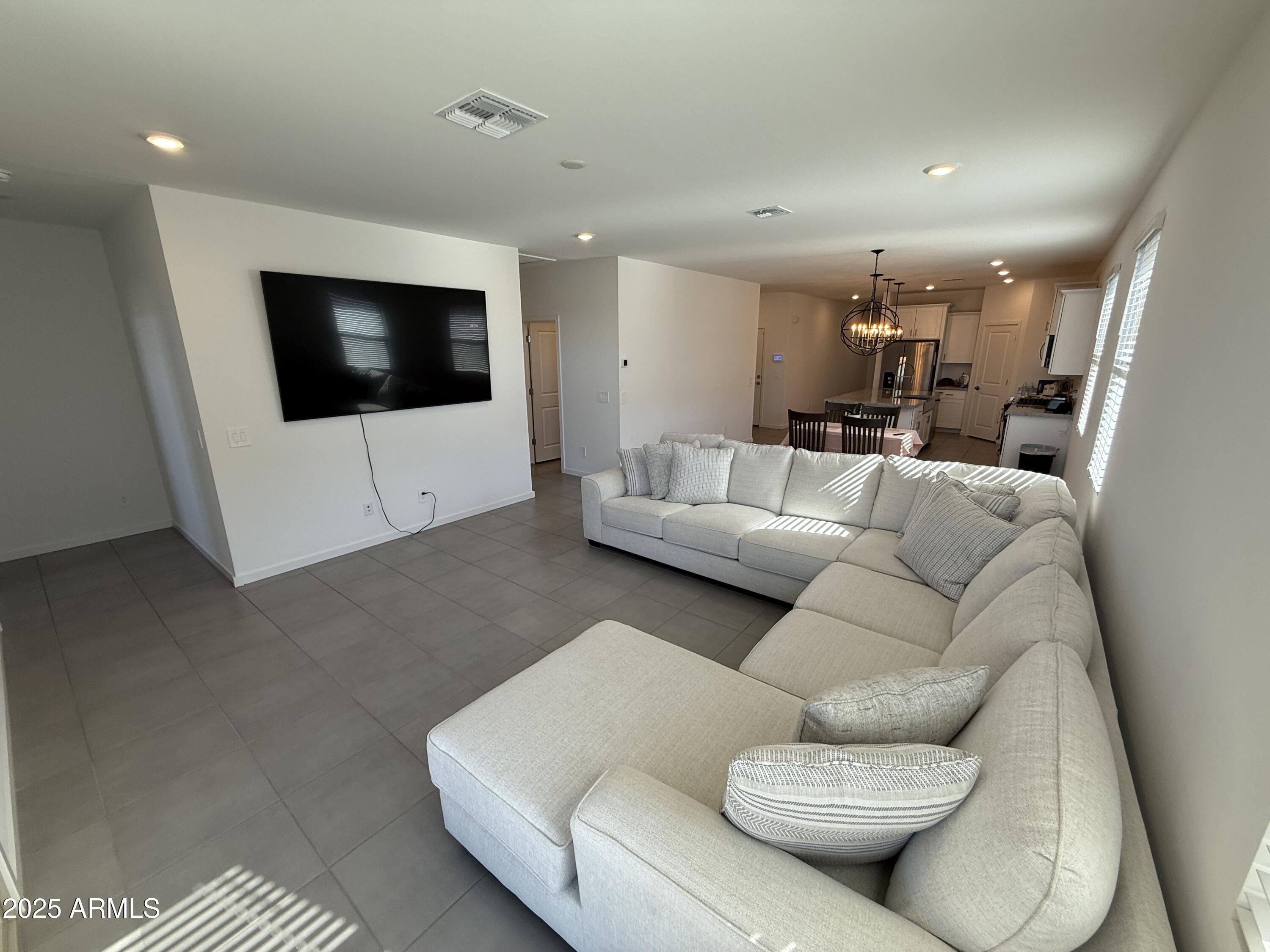 8534 West Warner Street Tolleson, AZ 85353 - Photo 11 of 36 a living room with furniture and a flat screen tv
