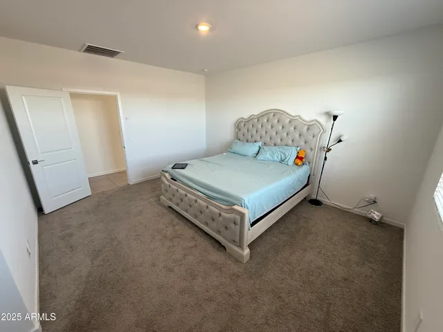 a bed sitting in a room next to a lamp