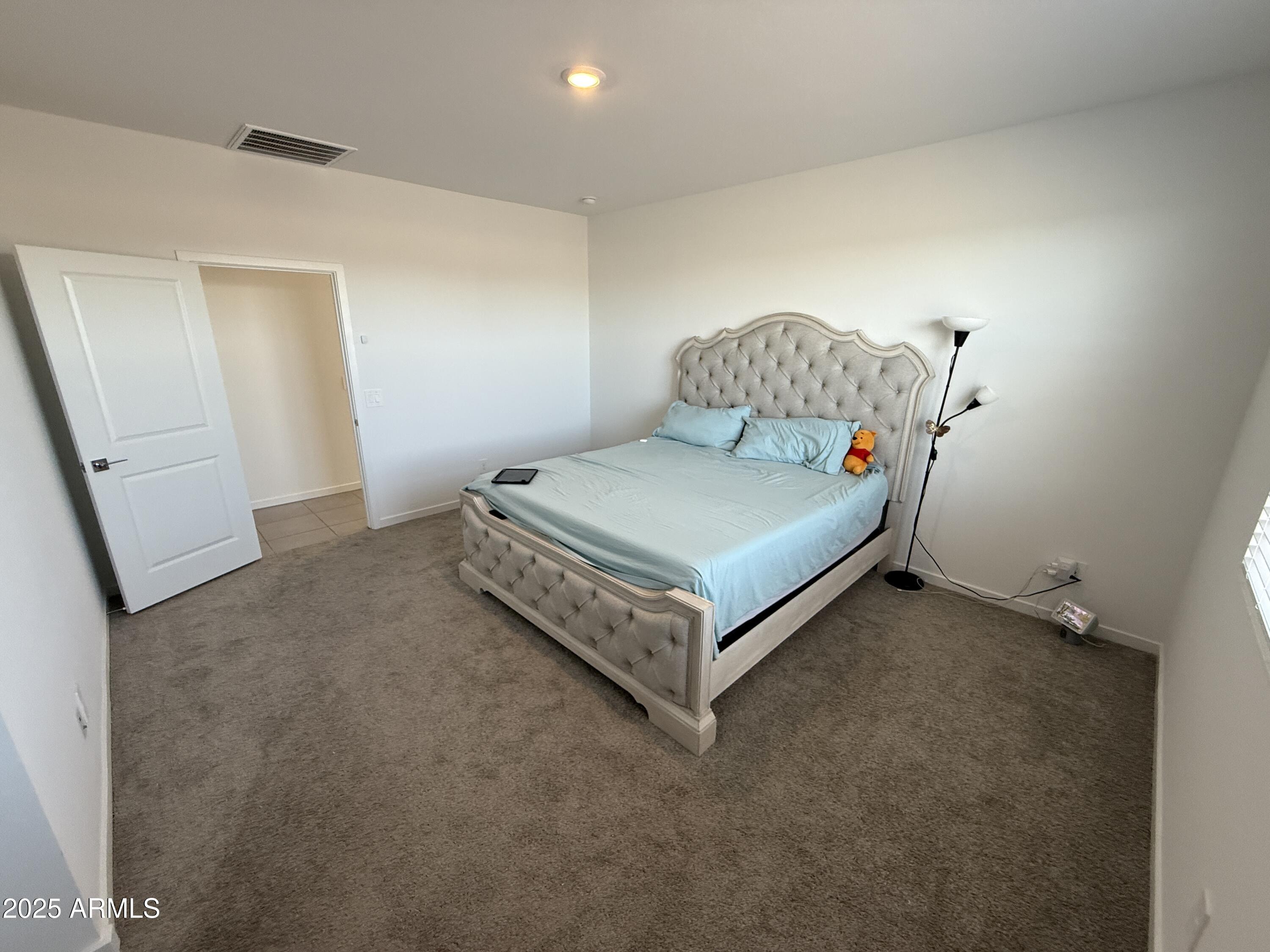 8534 West Warner Street Tolleson, AZ 85353 - Photo 13 of 36 a bed sitting in a room next to a lamp