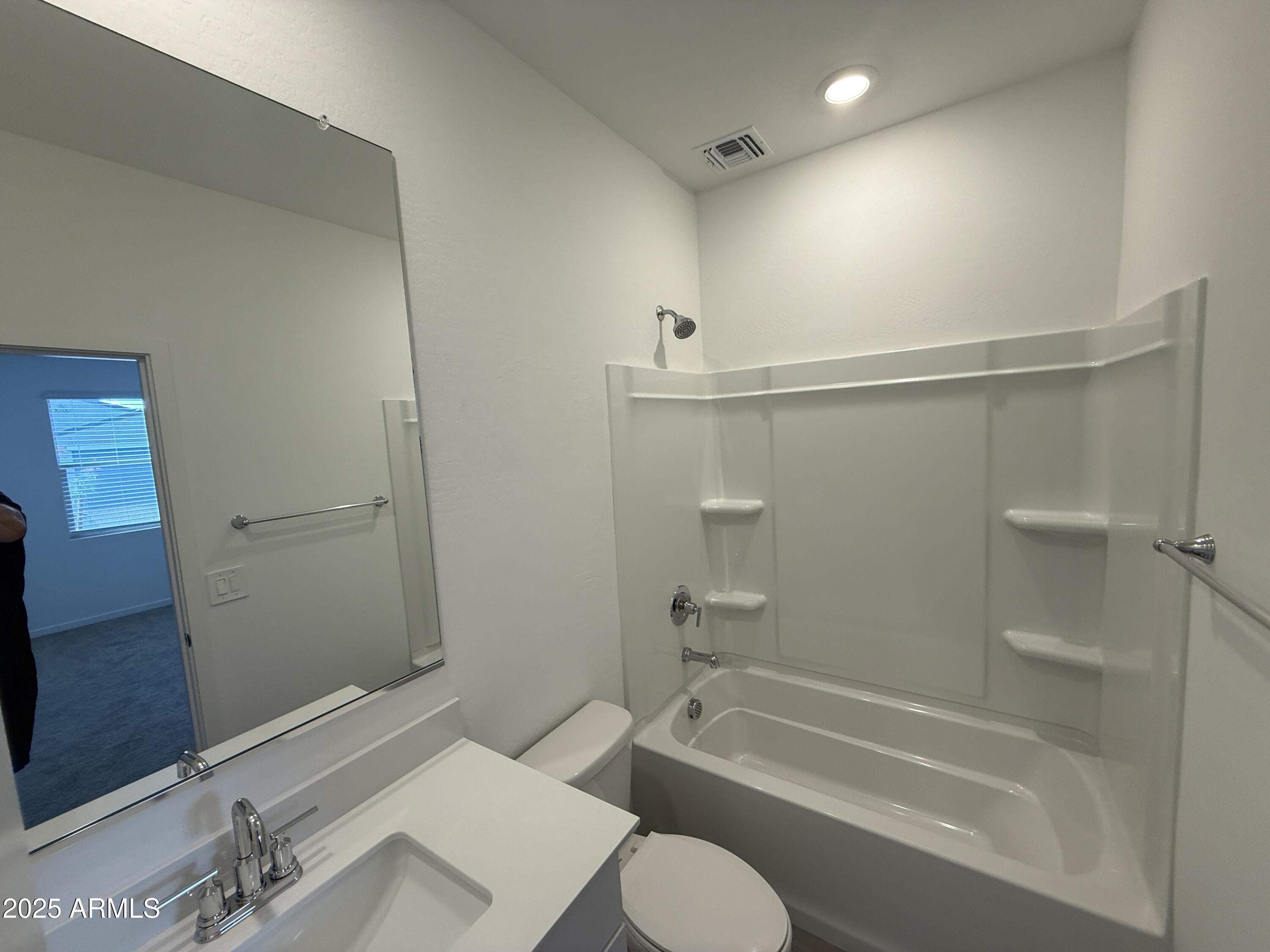 8534 West Warner Street Tolleson, AZ 85353 - Photo 21 of 36 a bathroom with a granite countertop bathtub shower sink vanity and toilet
