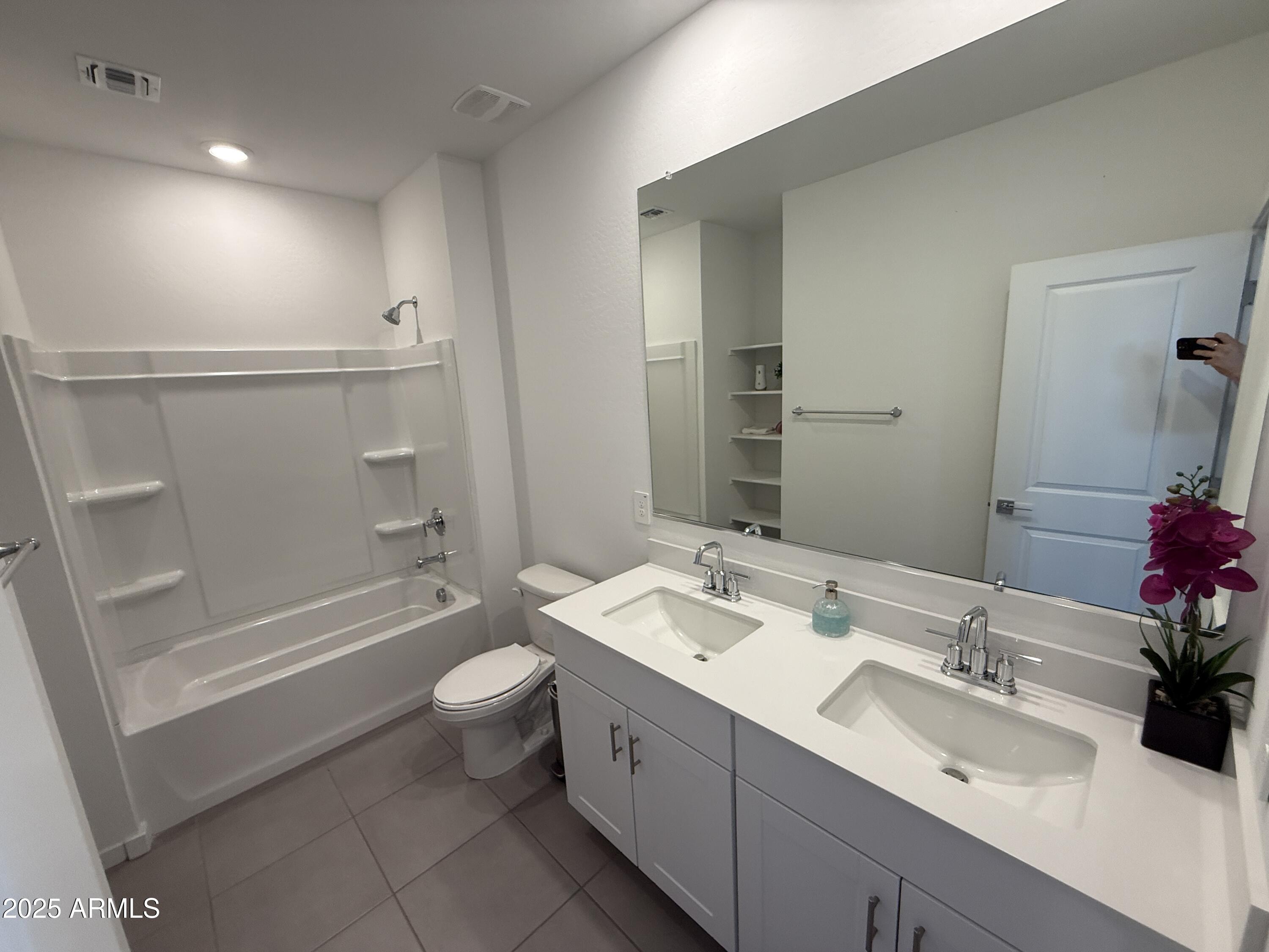 8534 West Warner Street Tolleson, AZ 85353 - Photo 34 of 36 a bathroom with a double vanity sink toilet mirror and shower