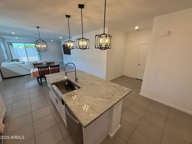 a kitchen with a sink a counter space and chandelier