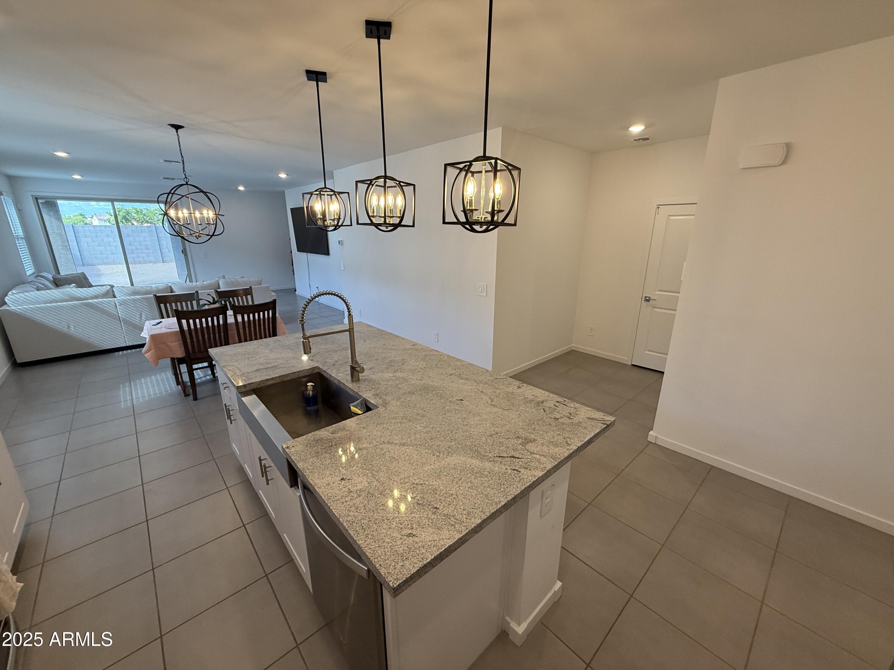8534 West Warner Street Tolleson, AZ 85353 - Photo 5 of 36 a kitchen with a sink a counter space and chandelier