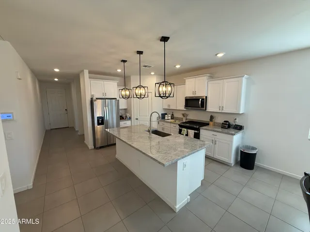 a open kitchen with stainless steel appliances granite countertop a stove top oven a sink dishwasher and a refrigerator