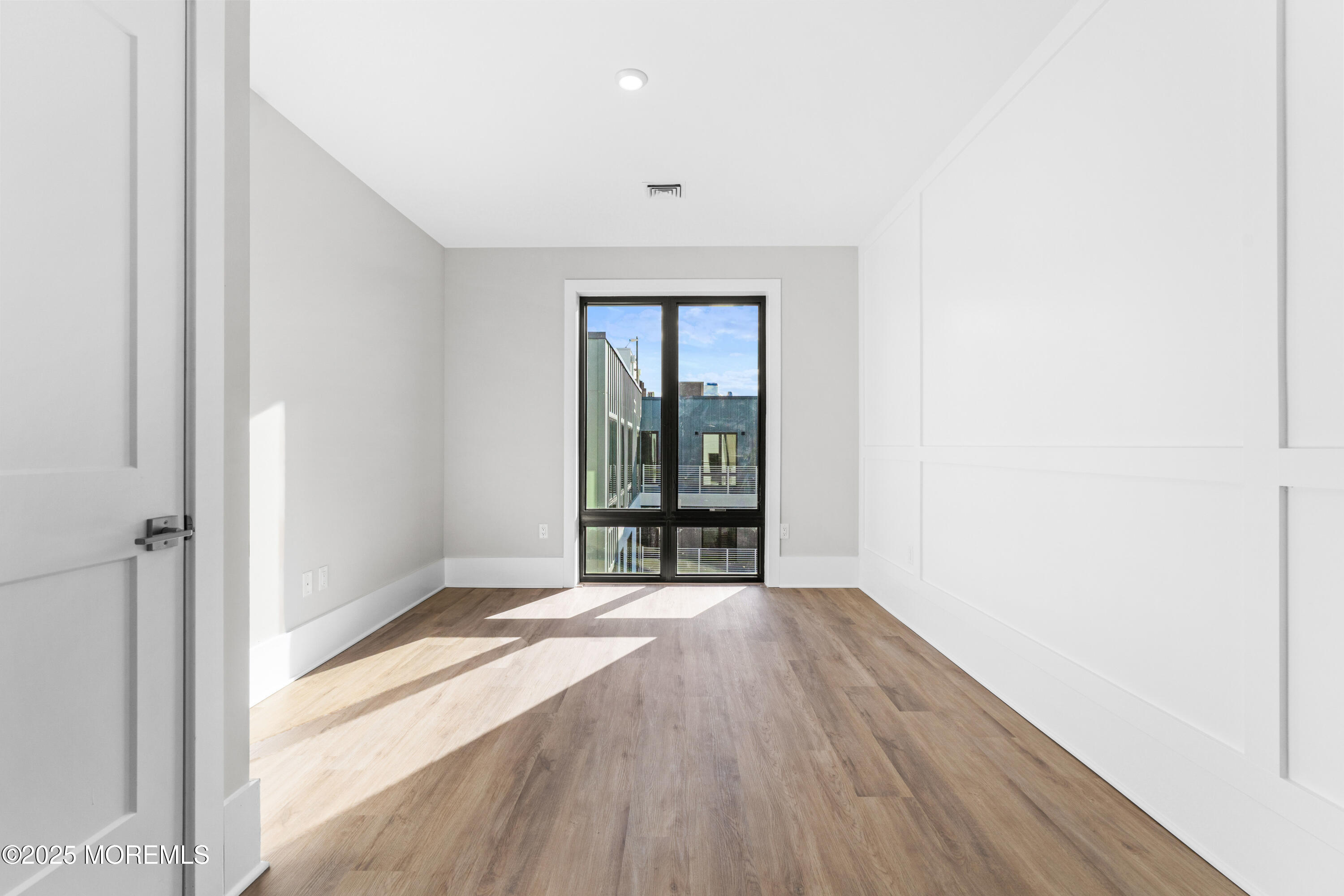 218 3rd Avenue, Unit 306 Asbury Park, NJ 07712 - Photo 39 of 66 a view of an empty room with wooden floor and a window
