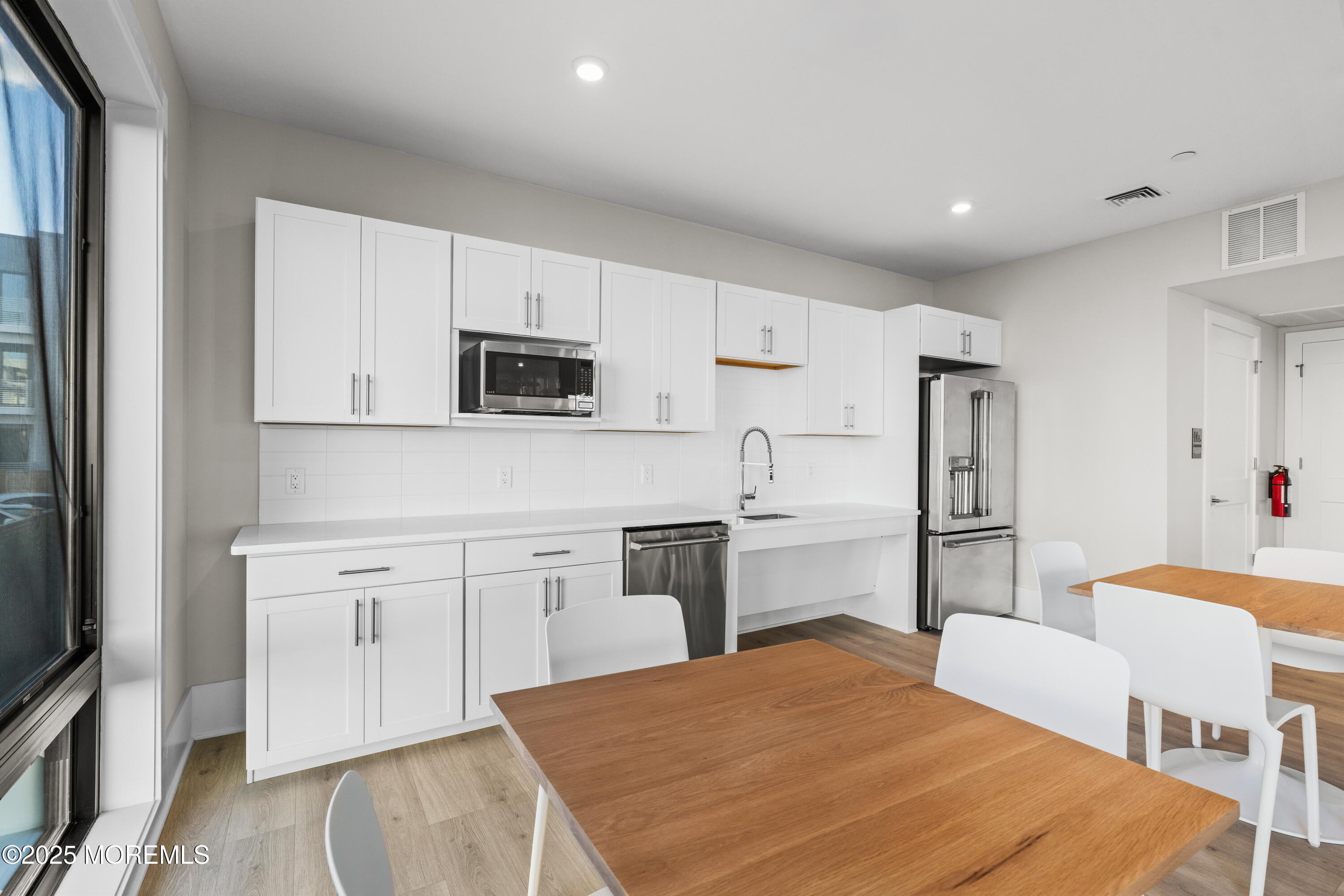 218 3rd Avenue, Unit 306 Asbury Park, NJ 07712 - Photo 48 of 66 a kitchen with stainless steel appliances granite countertop a refrigerator a stove top oven a sink dishwasher and white cabinets with wooden floor